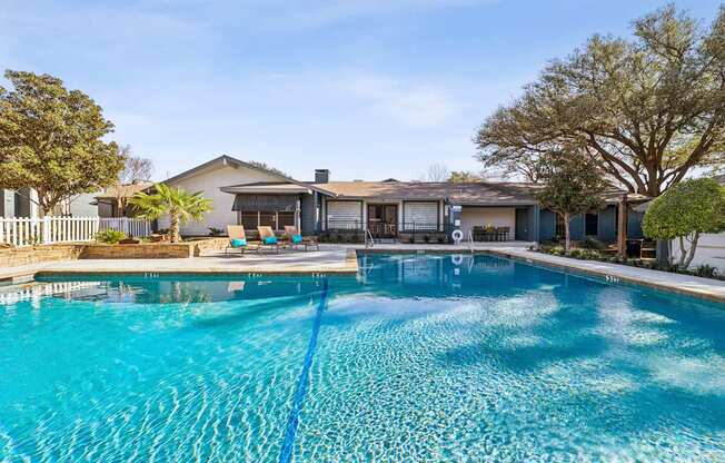 A swimming pool in front of a house.