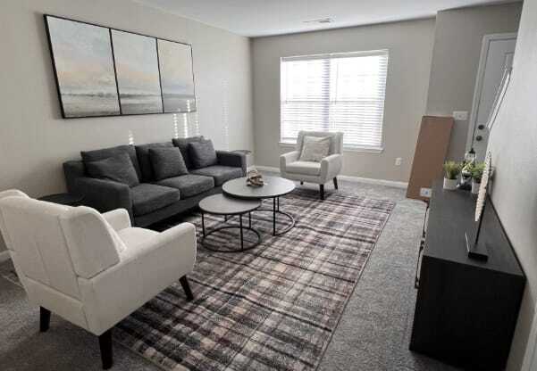 A living room with a grey couch, a white chair, and a coffee table.
