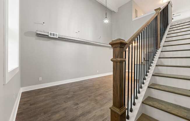 The landing of a staircase and living room at Crogman School Lofts, Atlanta, 30315