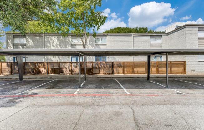 an empty parking lot in front of an apartment building