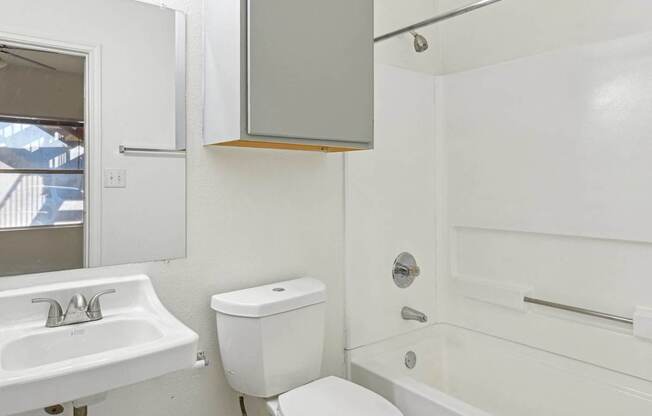 Affordable Apartments for Rent in Austin, TX 78724 – Huntington Meadows – A white bathroom with a toilet, sink, and bathtub.