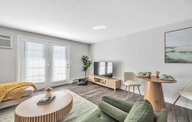 A living room with a green couch, a wooden coffee table, and a television.