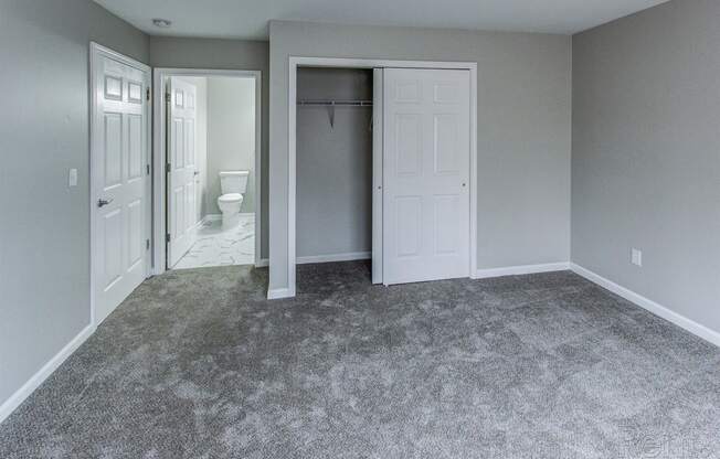 an empty room with a closet and a bathroom