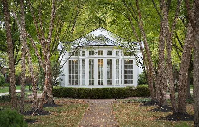 a white house in the woods with trees