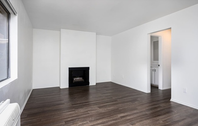 an empty living room with white walls and a fireplace