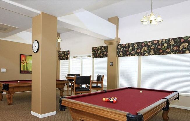a living room with a pool table and a dining table