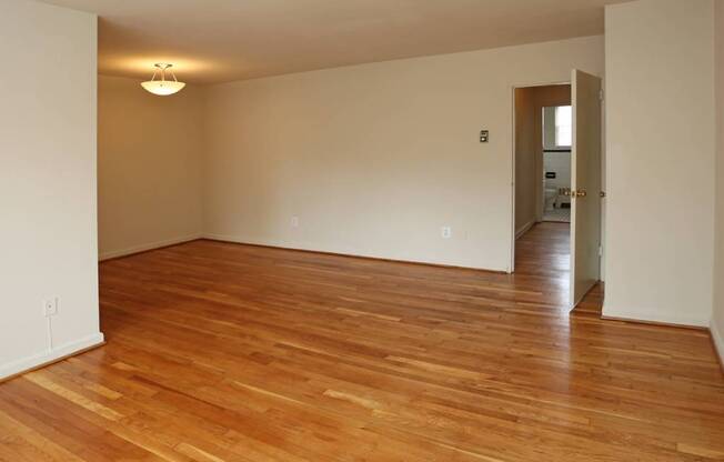 A room with wooden flooring and a doorway leading to another room.Battery lane apartments in Bethesda maryland