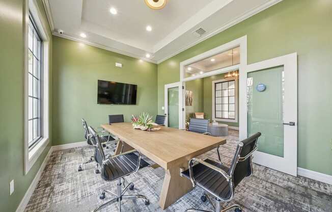 A conference room with a long table and chairs.