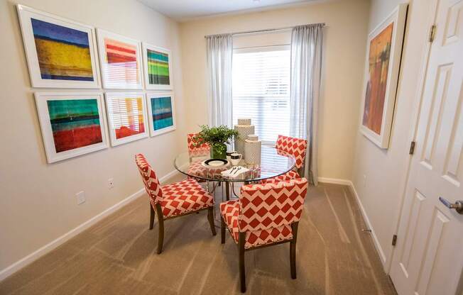 A dining room with a table and chairs.