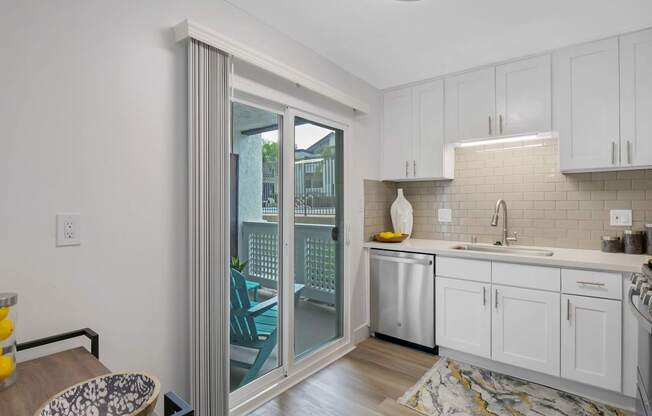 A kitchen with white cabinets and a marble floor at Verandas Apartments, California, 91791