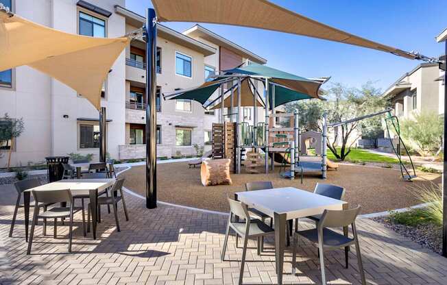 A patio with tables and chairs and umbrellas.