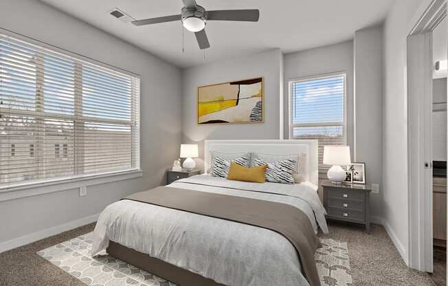 A bedroom with a large bed and a ceiling fan.