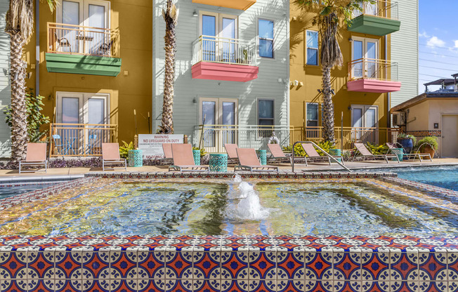 a pool with a fountain in front of a building