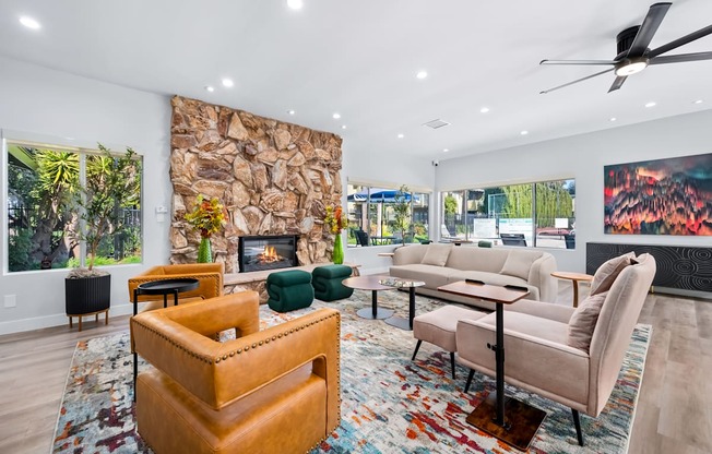 A living room with a stone fireplace and a painting of a forest fire.