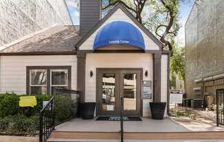 A small building with a blue awning that says Leasing Center.