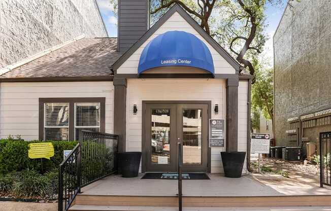 A small building with a blue awning that says Leasing Center.