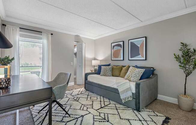 A bedroom with a bed, a chair, and a rug.