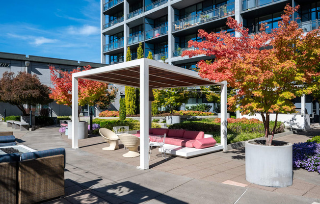 a terrace with a couch and chairs under a canopy