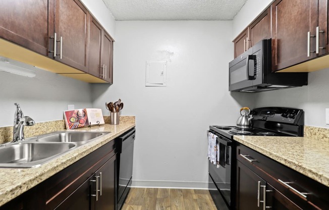 a kitchen with dark wood cabinets and granite countertops