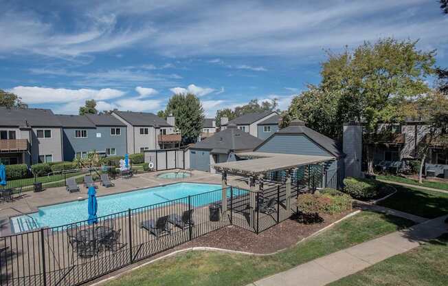 A pool surrounded by a fence and chairsat Sierra Glen Apartments, California, 95621