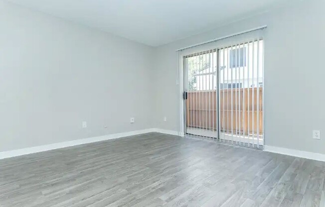 Explore the spacious interiors of Cali Crossing Apartments, where modern comfort meets style. Enjoy the serene sliding door that opens to your outside space and the sleek flooring that enhances your living experience. Schedule a tour today!