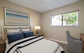 A bedroom with a large bed and a painting on the wall.