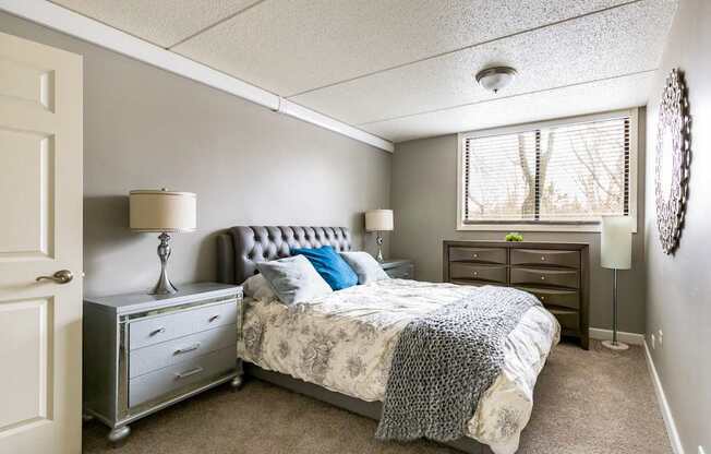 A bedroom with a bed, nightstand, and lamp.