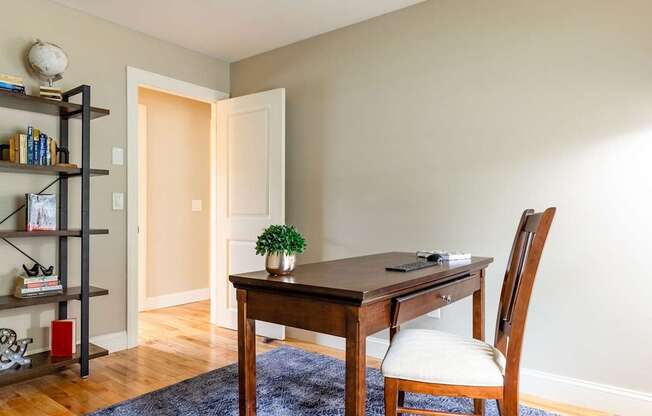 A room with a desk, chair, and bookshelf.