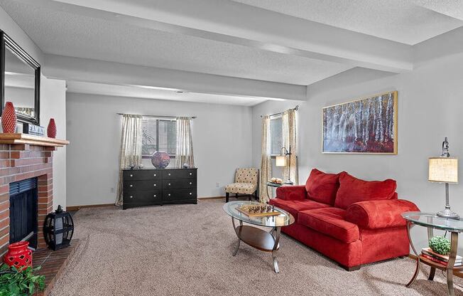 a living room with a red couch and a fireplace