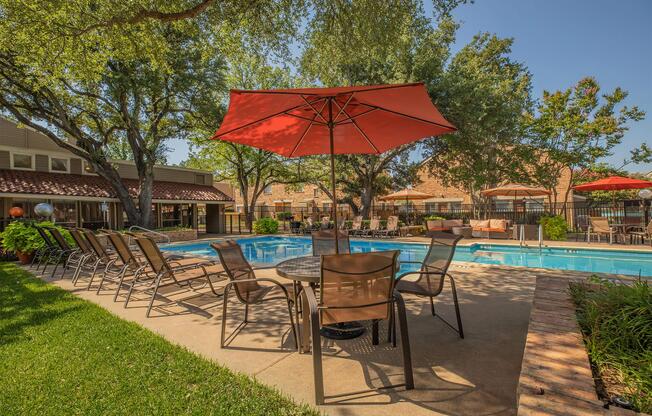 a group of lawn chairs under an umbrella