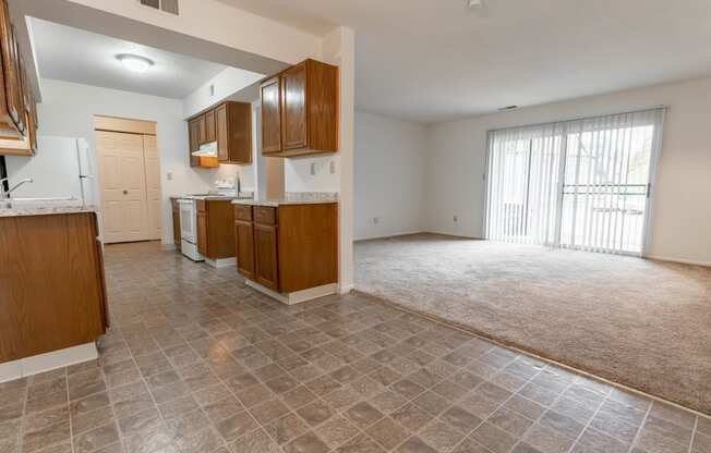 the kitchen and living room of an empty house with a large window