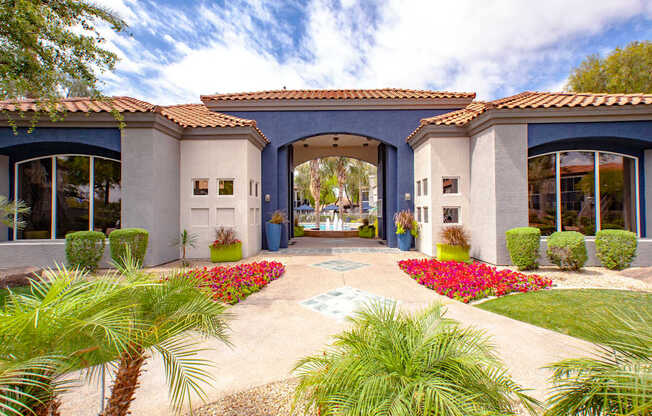 A house with a blue roof and white walls with a garden in front.