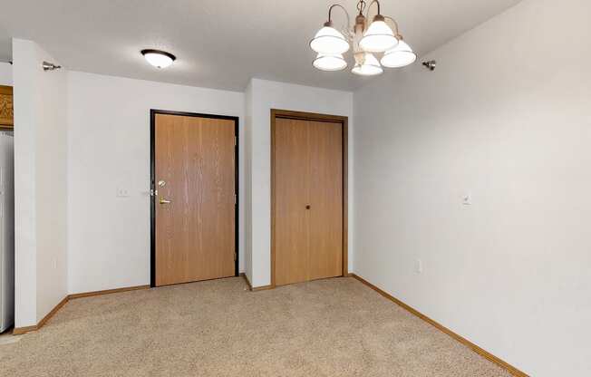 a room with a carpeted floor and a door to a closet