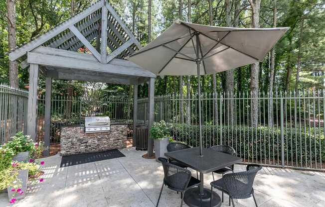 a patio with tables and chairs under a canopy with plants at Gwinnett Pointe, Norcross, GA, 30093