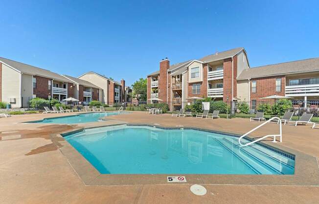 A swimming pool in front of apartment buildings.