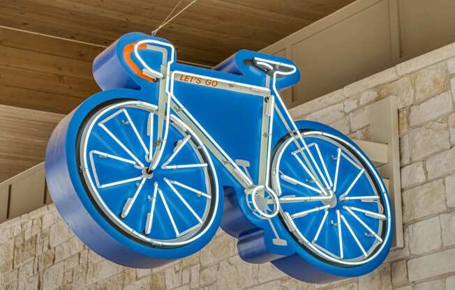 a blue bicycle sign hanging from the side of a building