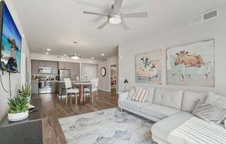 A living room with a white couch and a rug.
