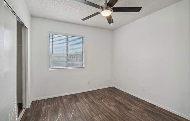 the living room of our studio apartment atrium with a ceiling fan and a window
