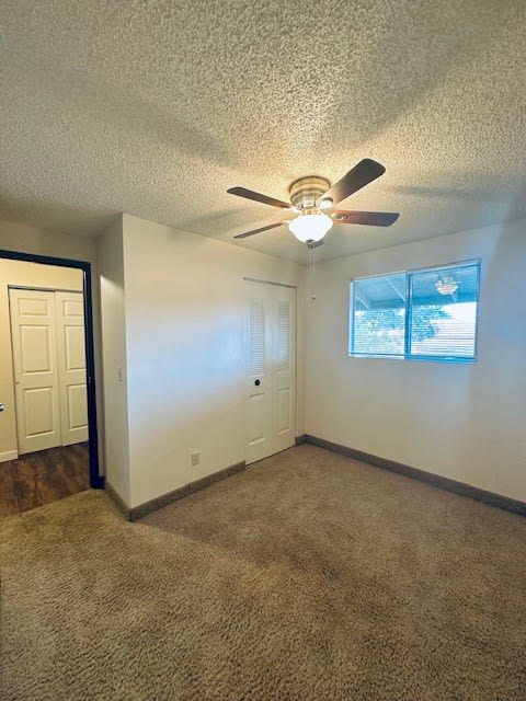 an empty room with a ceiling fan and a door