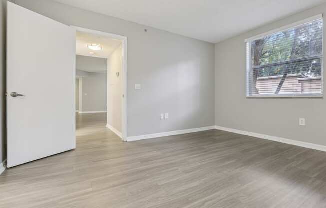 an empty living room with a large window and wood flooring at Pembroke Pines Landings, Pembroke Pines, FL 33025