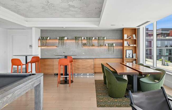 A room with a pool table and a bar area.