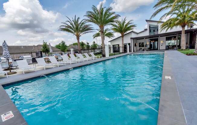 A large swimming pool with a staircase leading to a house.