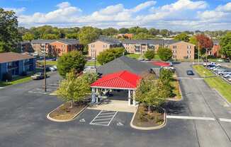 A parking lot with a red-roofed building in the middle.