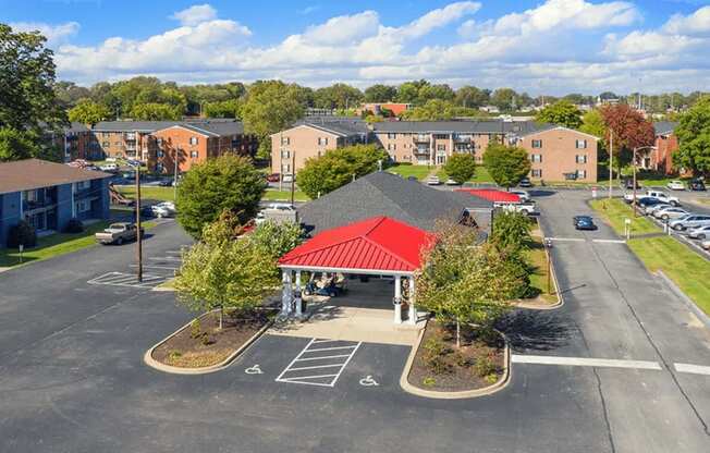 A parking lot with a red-roofed building in the middle.