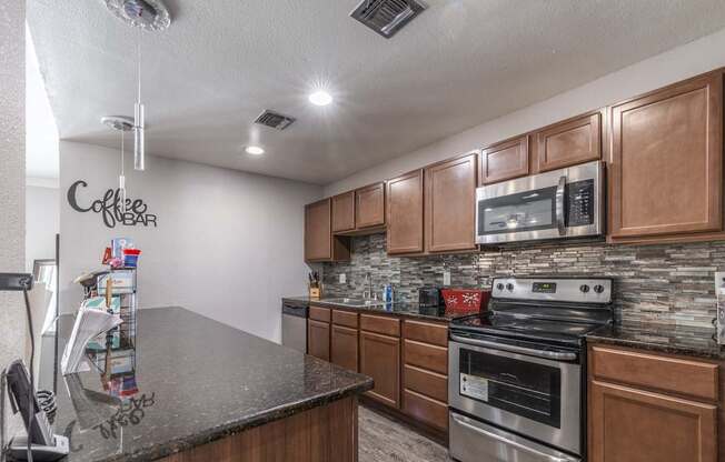 A kitchen with a granite countertop and wooden cabinets.