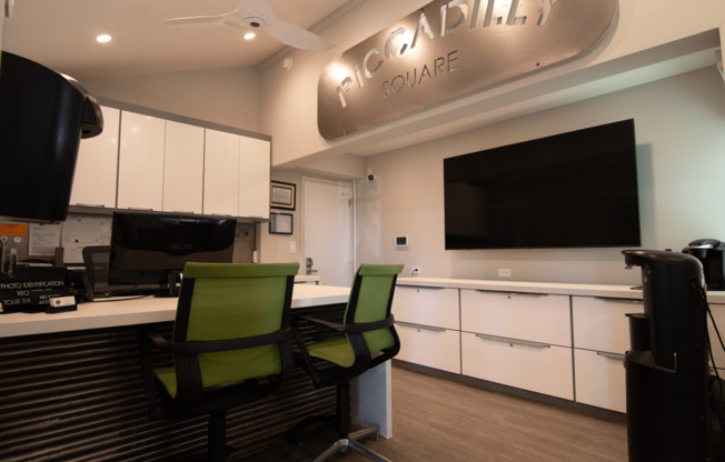 Two green chairs are in front of a white counter with a sign that says 