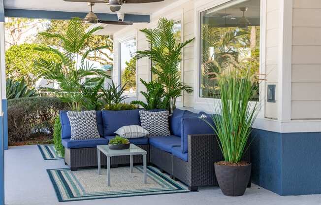 a porch with blue furniture and potted plants