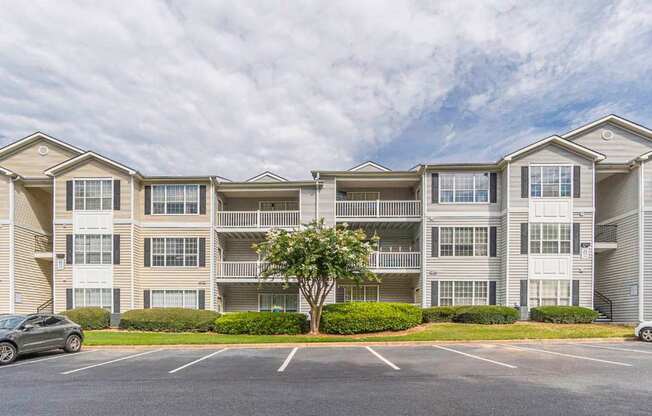 A large apartment complex with a parking lot in front.