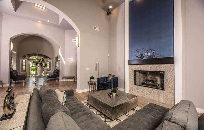 A living room with a grey couch and a fireplace.