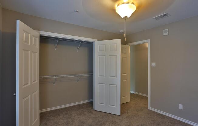 carpeted bedroom with open closet doors